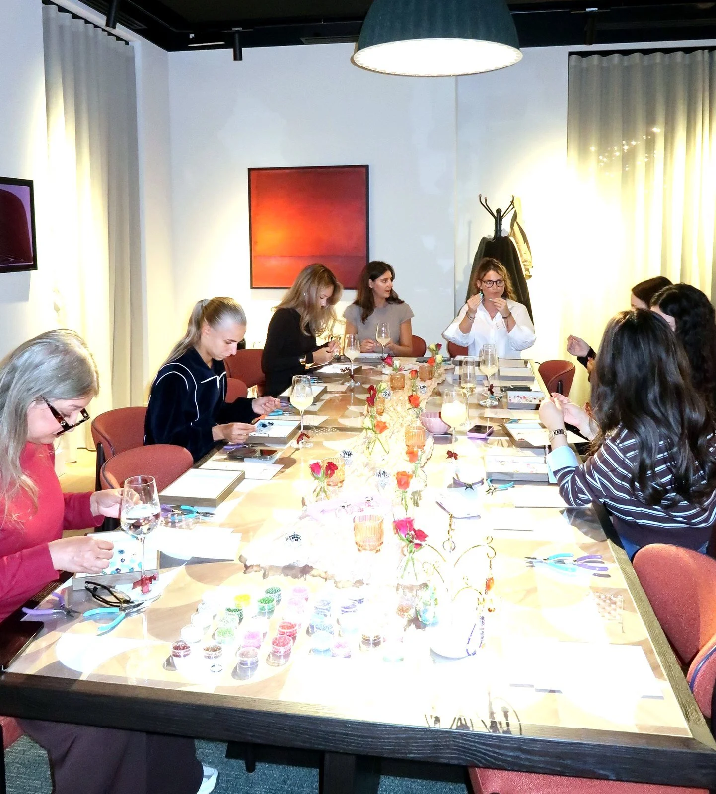 A full table of guests at a Petals & Pearls private jewellery-making workshop in London, each making their own beaded bracelet and keyring.