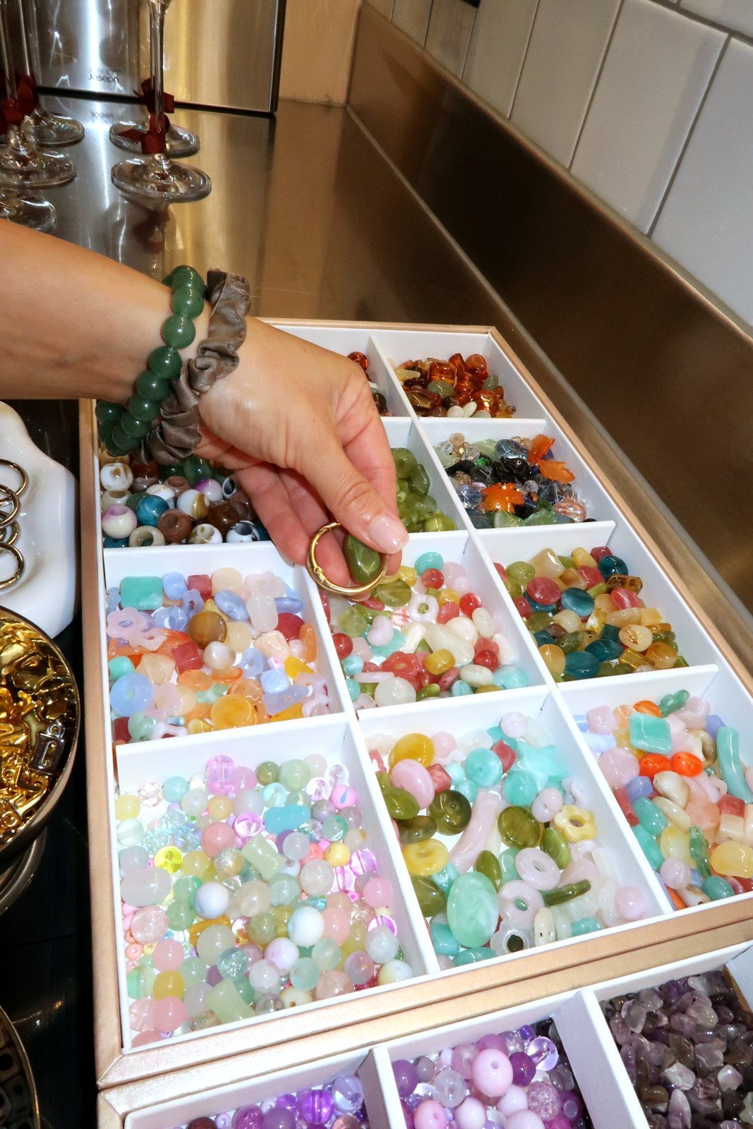 A guest choosing beads from the Petals & Pearls bead bar at a London jewellery-making workshop.