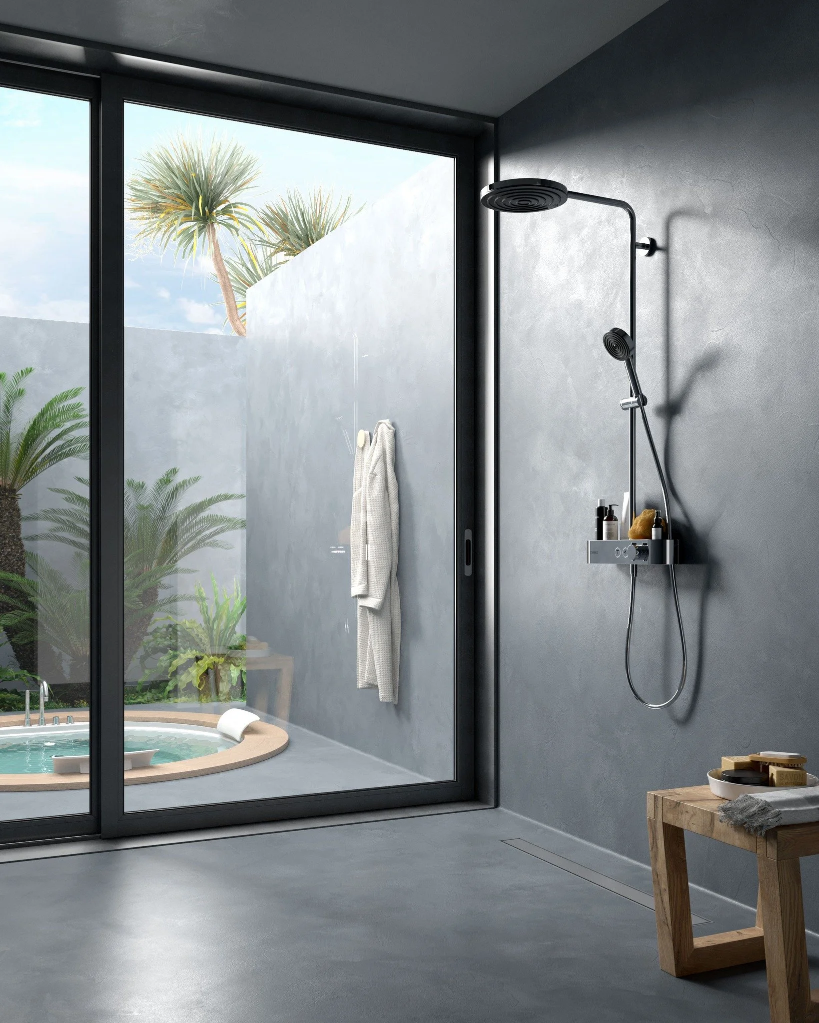 Modern bathroom with gray concrete walls and floor, large window with outdoor plants, rain shower head on wall, small wooden table with a bar of soap and towels.