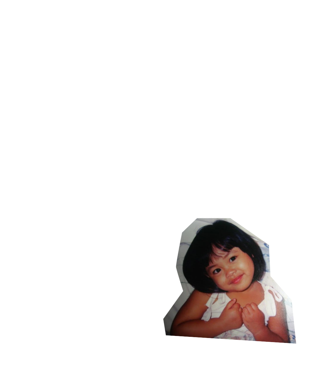 Young girl with short black hair and a white dress, smiling and holding her hands near her chest.