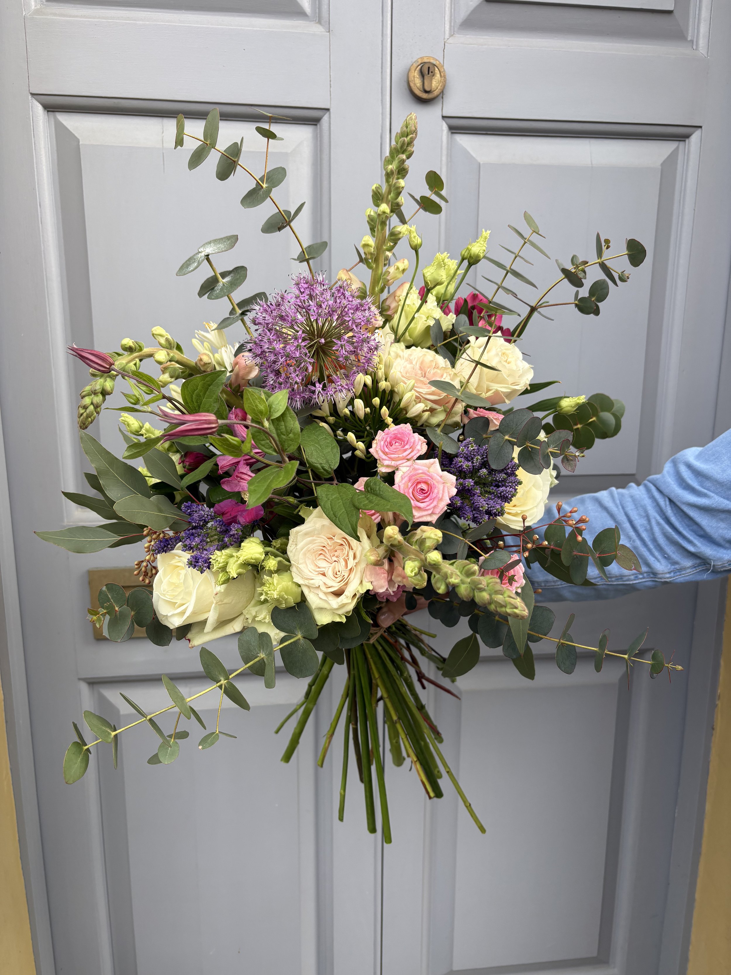 Stunning large bouquet of flowers in purples, punks and creams with seasonal foliage. Perfect for gifting