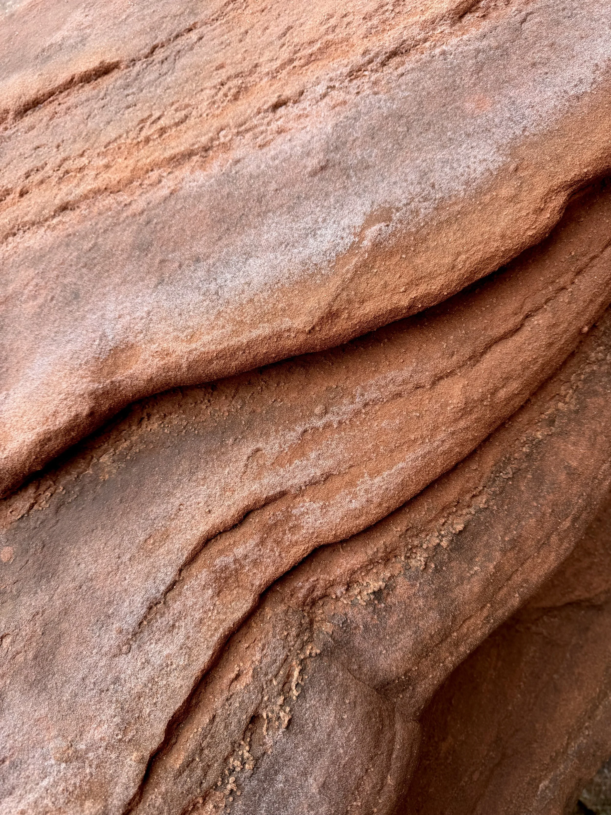 Close-up of layered red sandstone rocks with textured surface.