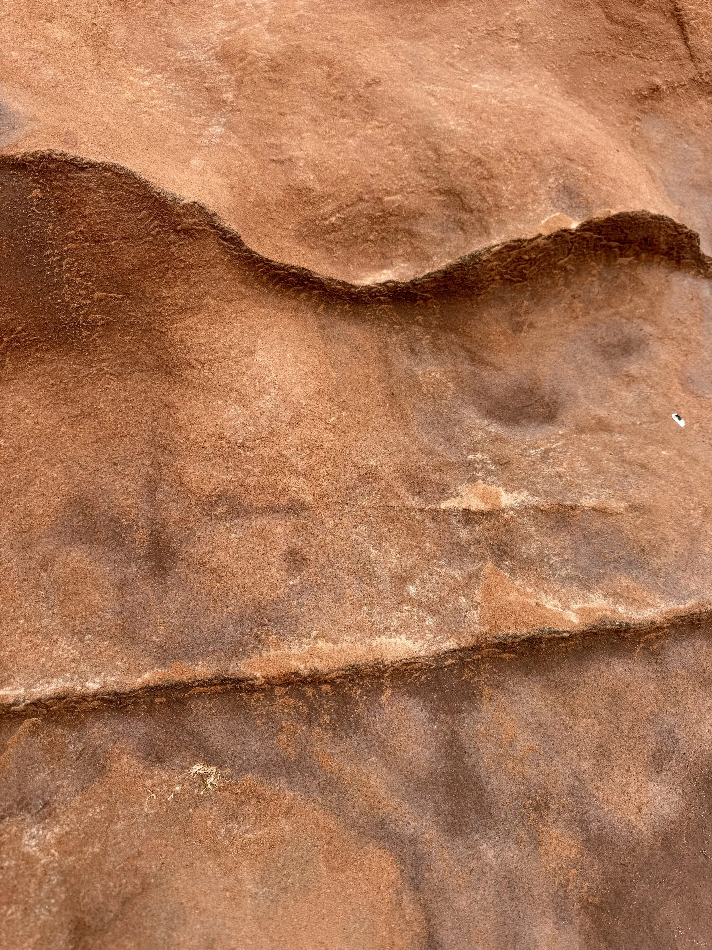 Close-up photo of a rusted metal surface with uneven texture and a prominent ridge running across the image.