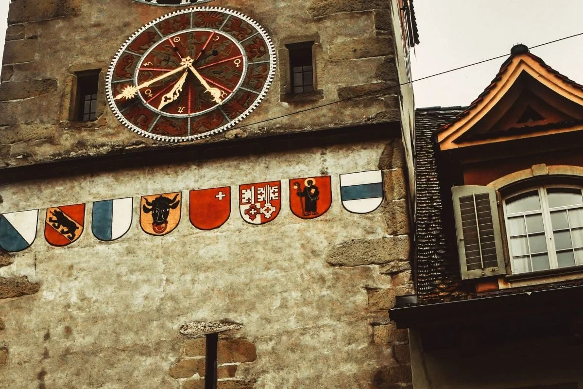 Kantonswappen und Uhr am Zytturm in Zug als Symbol für die Schweizer Geschichte und die Lernreise ins Landesmuseum Zürich.