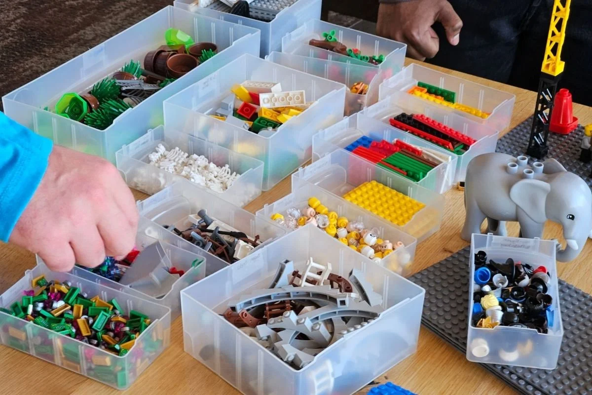 Teilnehmende arbeiten mit den sortierten Elementen des LEGO® SERIOUS PLAY® Identity & Landscape Sets