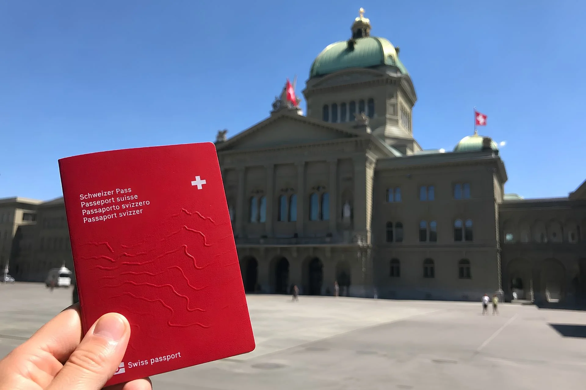 Schweizer Pass vor dem Bundeshaus in Bern als Symbol für die Einbürgerung und das Schweizer Bürgerrecht.
