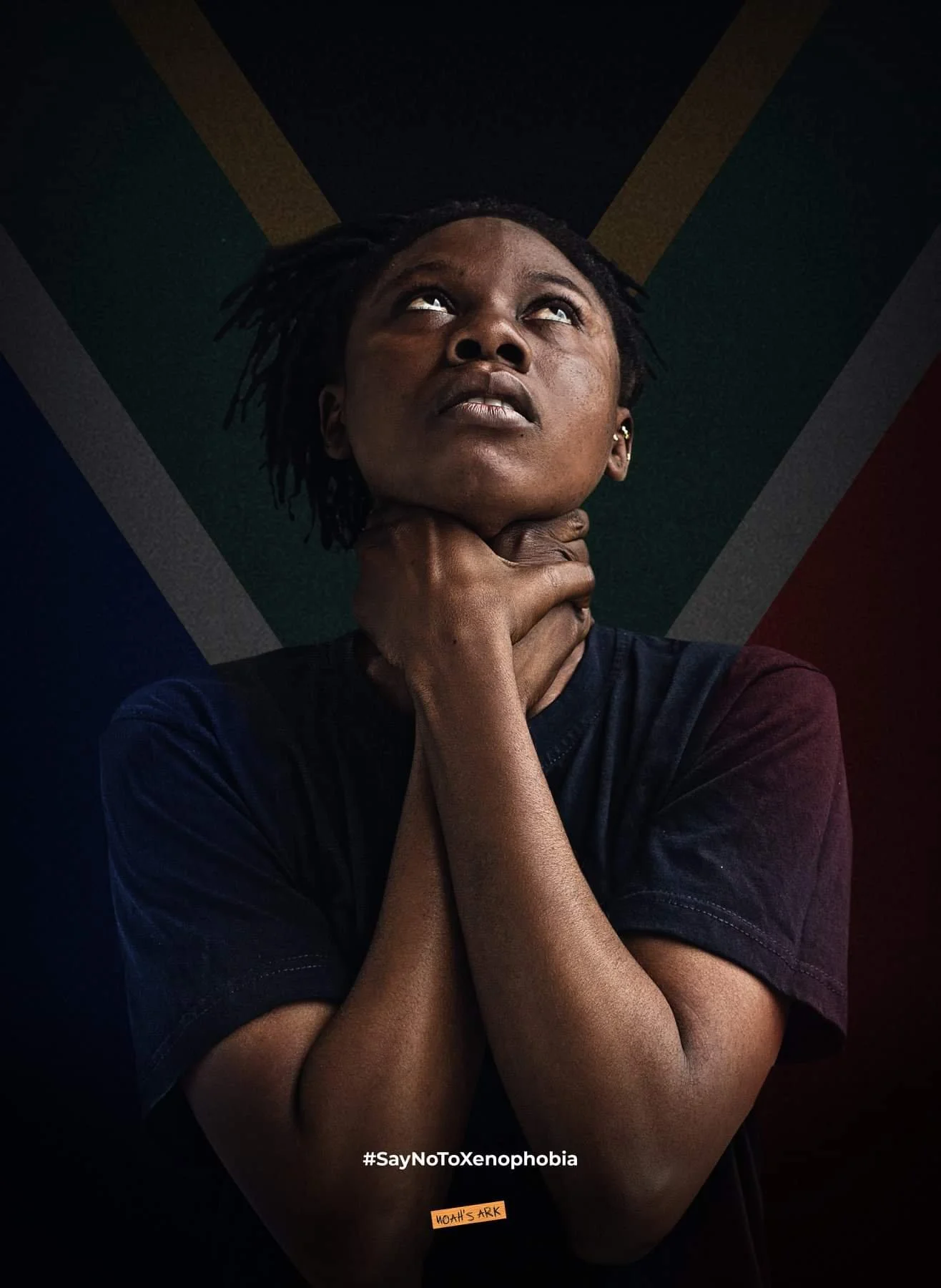 A Black woman looking upwards with her hand around her neck, against a backdrop of South African flag colors. The image promotes the message #SayNoToXenophobia and Moats ARK.