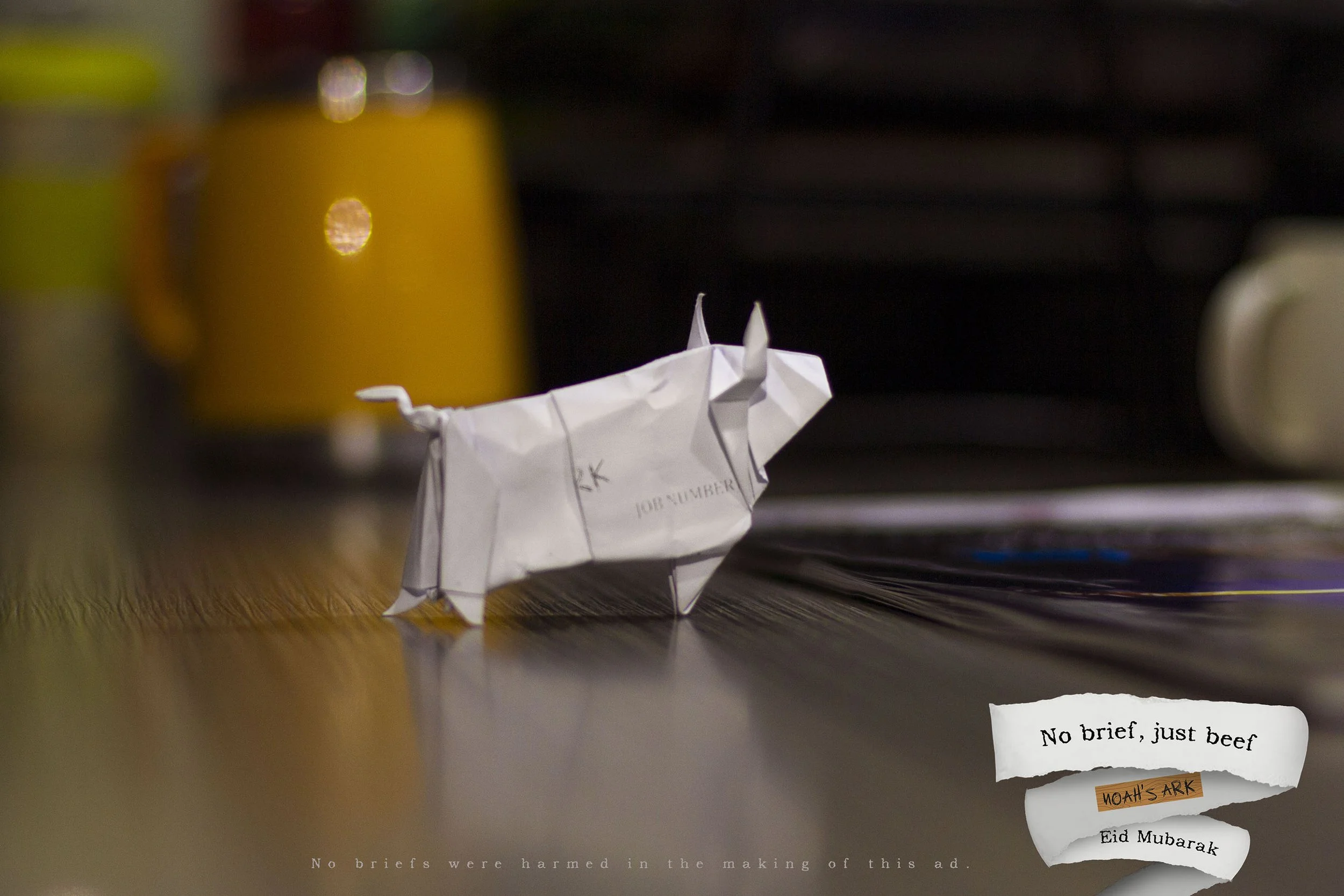 An origami unicorn on a wooden surface with a sticker that says 'No brief, just beef' and a handwritten note reading 'NOAH'S ARK' and 'Eid Mubarak' in the background.