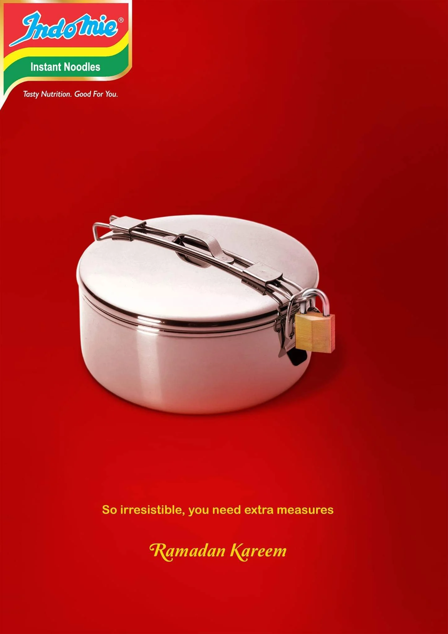 A red background with the IndoMie logo and the text 'Instant Noodles'. A metallic food container with a latching lid is also visible, along with a yellow padlock on the container. The text 'So irresistible, you need extra measures' and 'Ramadan Karee