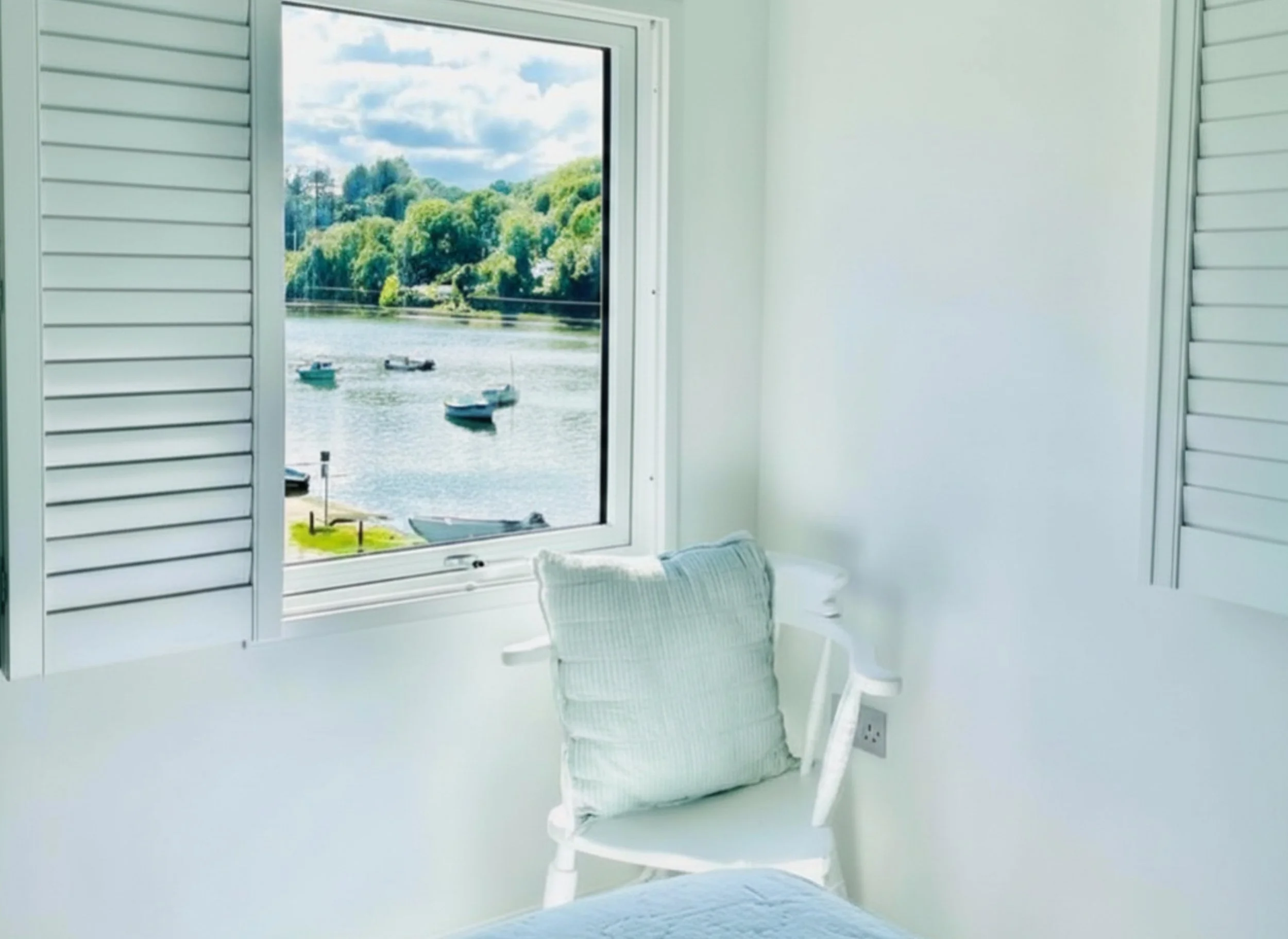 Inside Cobble Cottage. The Master bedroom. Bright room with windows overlooking Lerryn River.