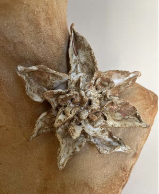 Une sculpture ou une figurine en forme de fleur  en céramique.