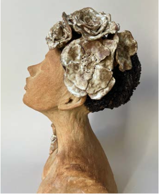 Statue en porcelaine ou en céramique représentant une femme de profil, avec une coiffure élaborée faite de fleurs ou de formes sculpturales.