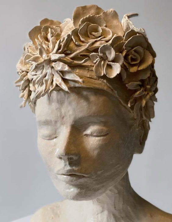 Statue d'une jeune fille avec des cheveux en forme de fleurs.