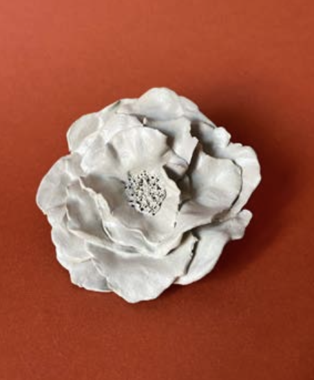 Une pêche blanche en papier sur un fond orange.