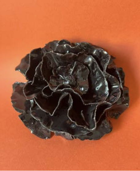Une gelée noire en forme de fleur sur un fond orange.