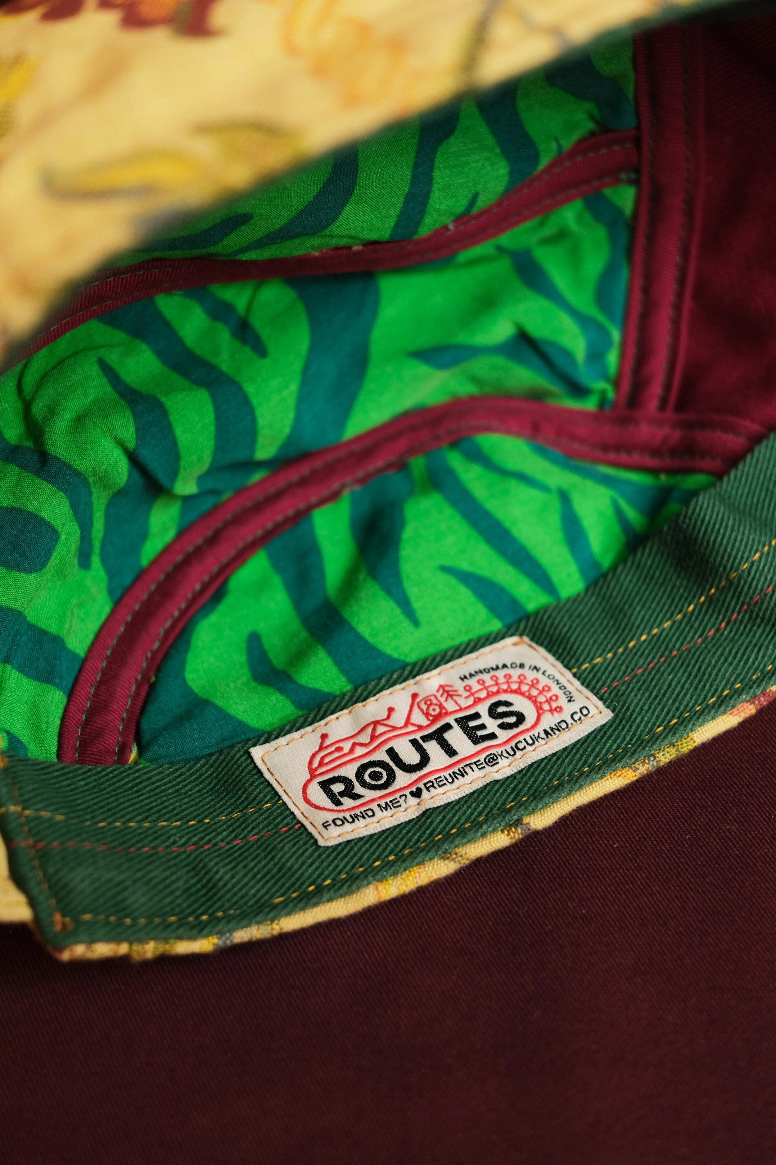 Close-up of the inside of a Vans backpack with a green and blue bandana lining and a Vans Route label.