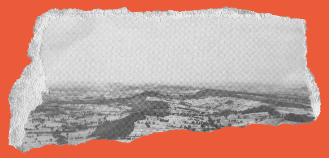 Torn piece of paper with a black-and-white aerial photograph of a rural landscape, including fields, trees, and hills, on a reddish-orange background.
