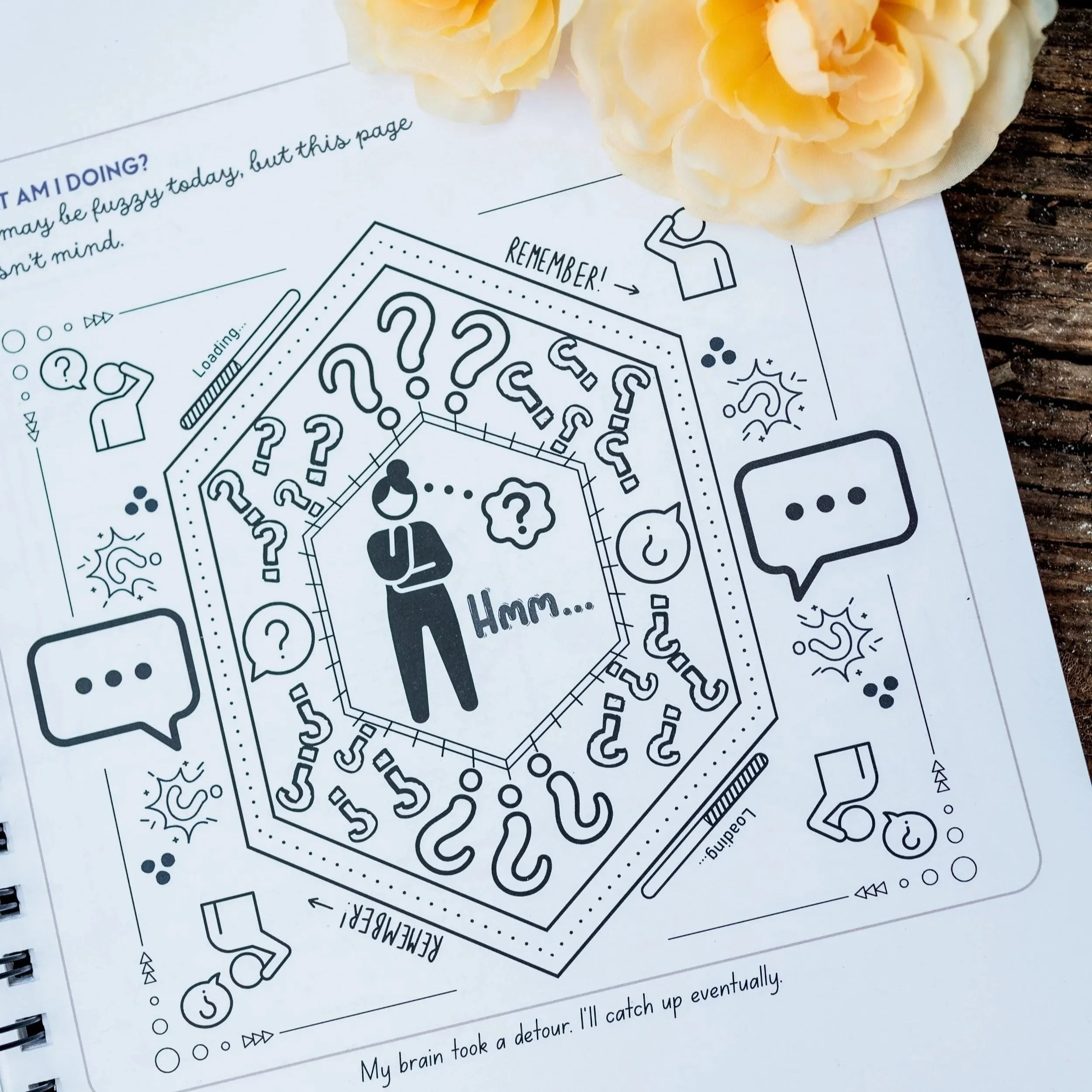 Close-up of a worksheet with a maze and questions, partially covered by light yellow flowers, placed on a wooden surface.