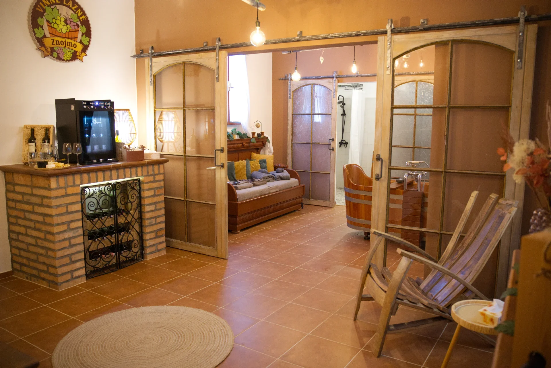 Cozy living space with brick and glass partitions, wooden furniture, and decorative lighting.