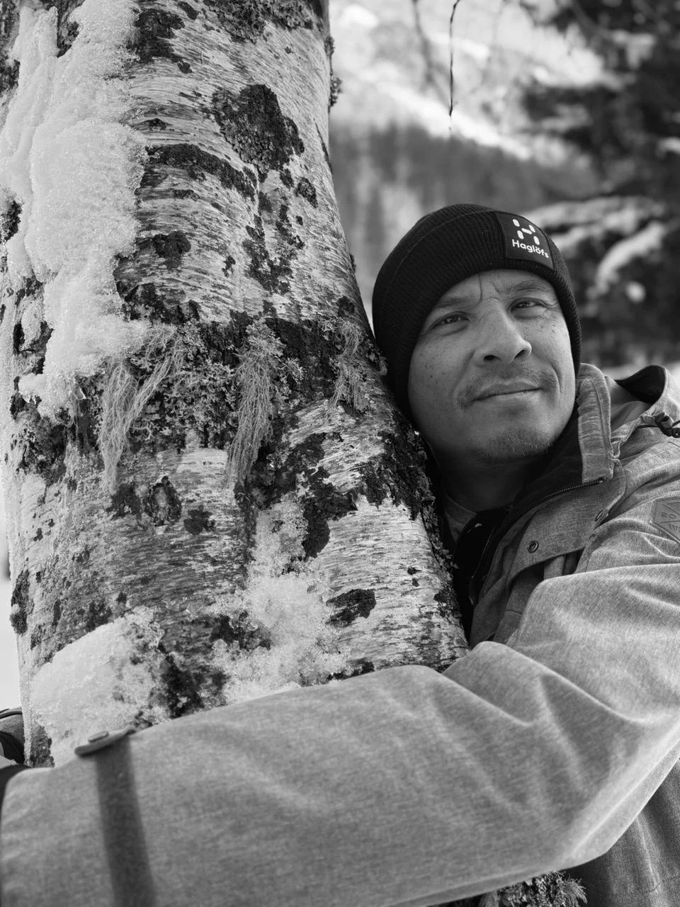 Thierry Planté souriant près d'un arbre enneigé en montagne, portant un bonnet et une veste à Chamonix
