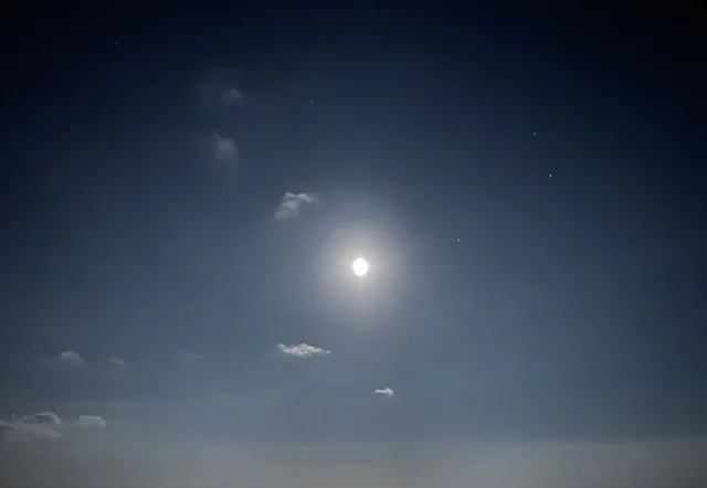 Ciel nocturne avec la lune brillante et quelques nuages légers dans le ciel de Sallanches