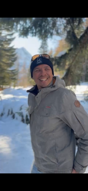 Thierry Planté souriant en tenue d'hiver à Chamonix dans un paysage enneigé avec des arbres et des montagnes en arrière-plan.