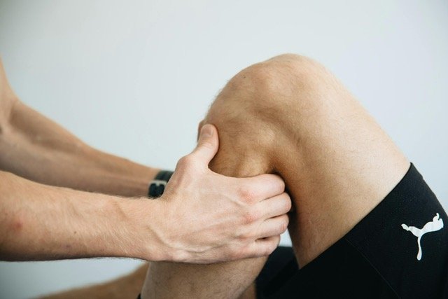 Une personne reçoit un massage ou une thérapie au genou par un massothérapeute. Thierry Planté