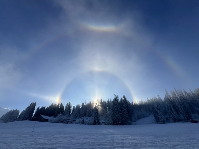 Arc en ciel par temps clair au-dessus d'une forêt enneigée, à Chamonix