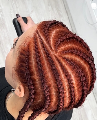 Top view of a person with intricately braided red hair, styled in multiple rows.