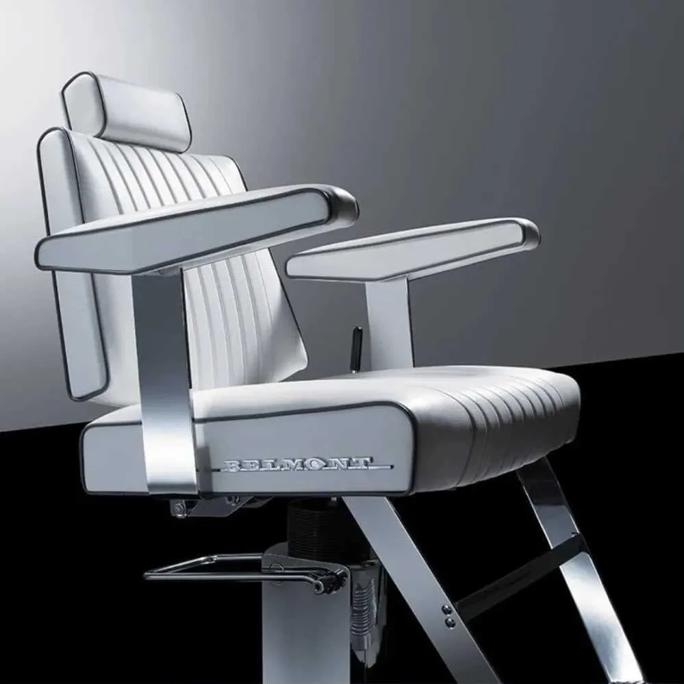 A vintage white barber chair with metal frame, cushion, armrests, and footrest, branded with the name 'BELMONT', against a plain background.