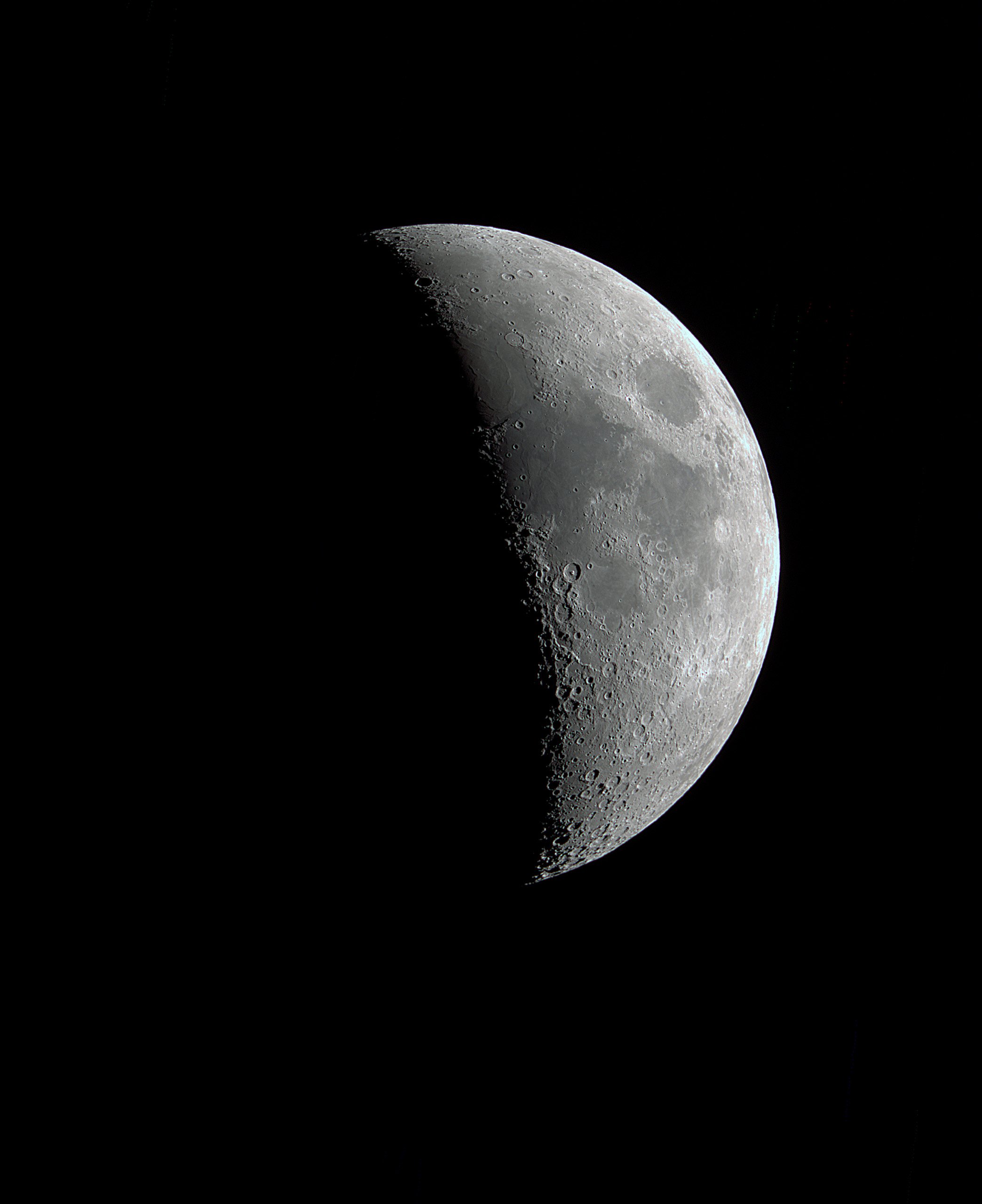 A close-up view of the moon showing its cratered surface against the blackness of space.
