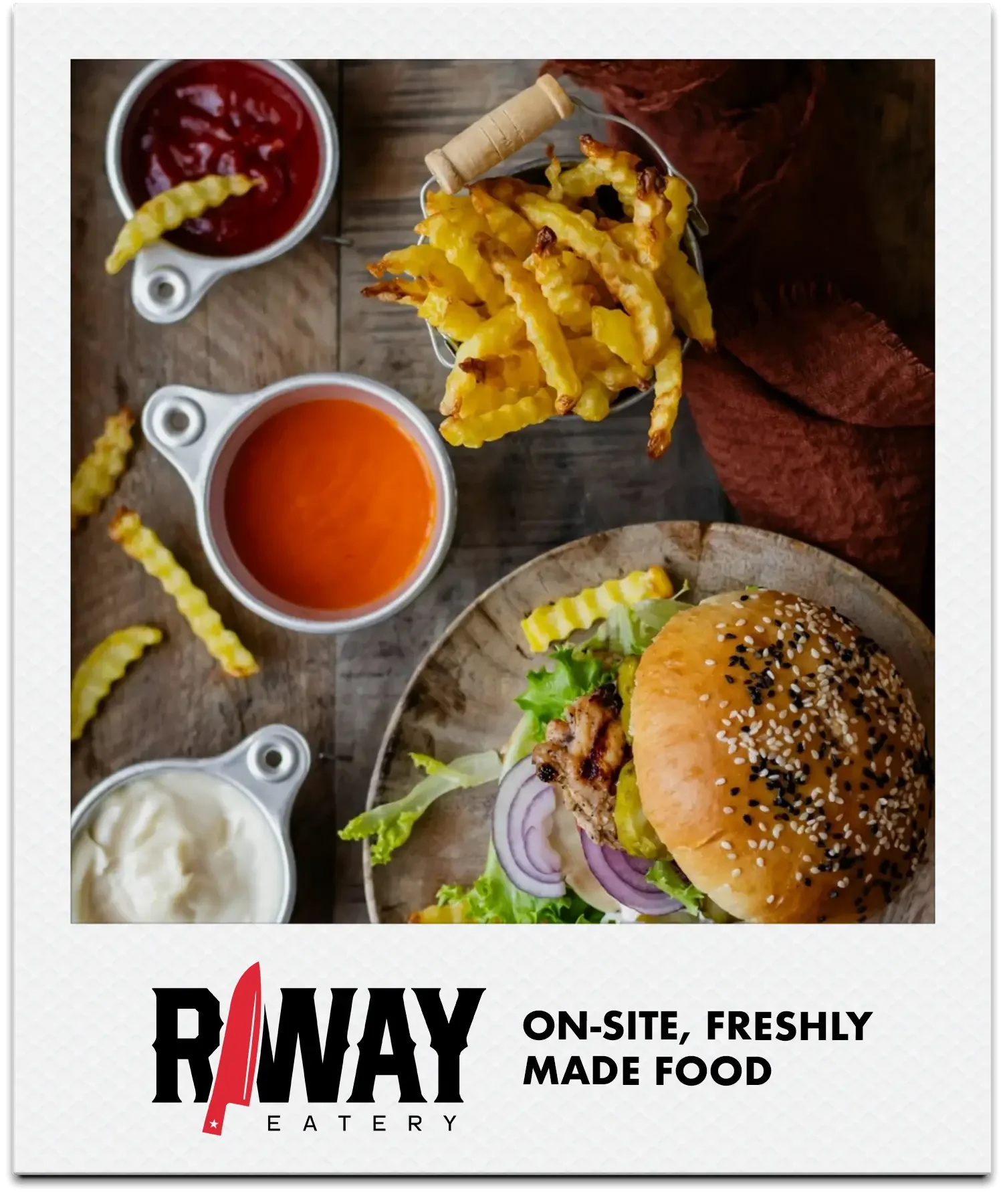 Close-up of a burger with sesame seed bun, lettuce, tomato, onion, and grilled meat. Served with crinkle-cut fries and small cups of ketchup, mustard, mayonnaise, and relish on a wooden table.