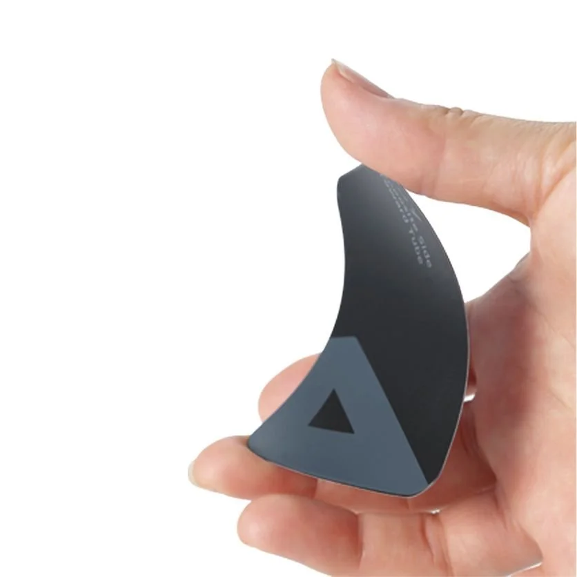 Close-up of a person's hand holding a curved black and gray device with a triangle cutout, displaying a minimalist design.