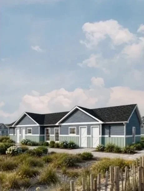 A modern blue house with white trim and a black roof, set in a landscaped yard with shrubs and a pathway, under a partly cloudy sky.