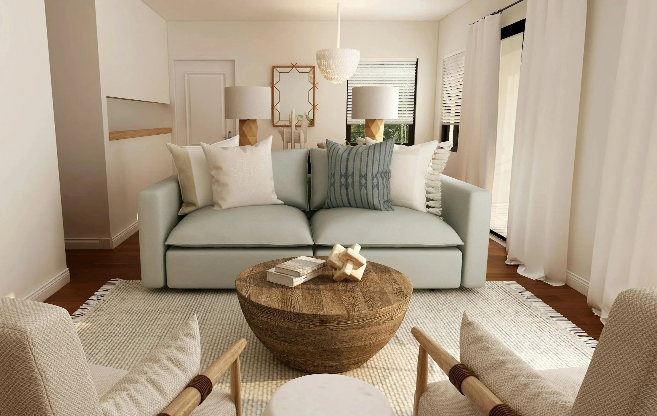 Living room with a white sofa decorated with pillows, a round wooden coffee table, and beige armchairs. The room features large windows with blinds, white curtains, and minimal wall decor.