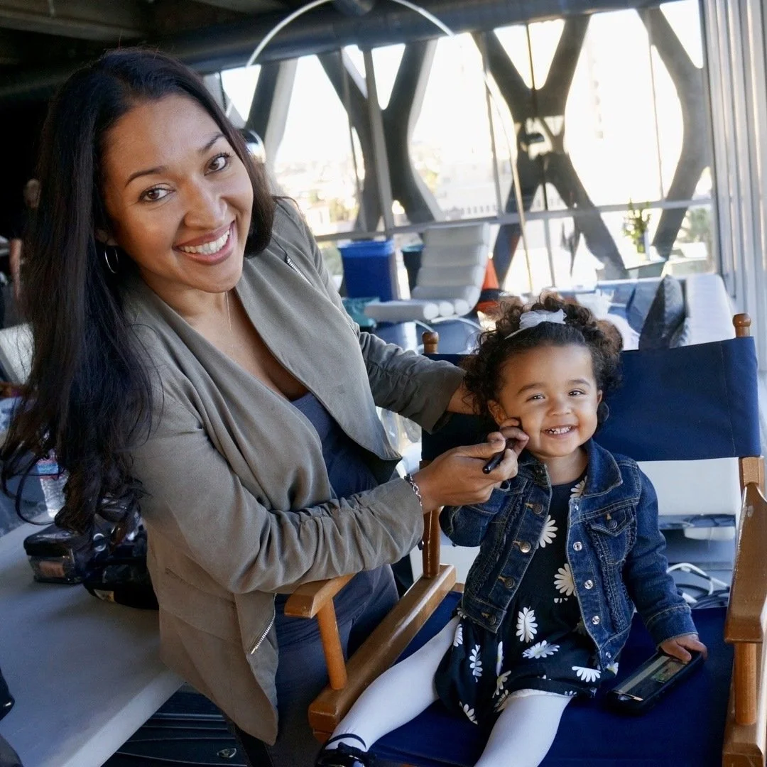 Zully Ortiz on set doing makeup touch-ups for her daughter Zuri in a director's chair.