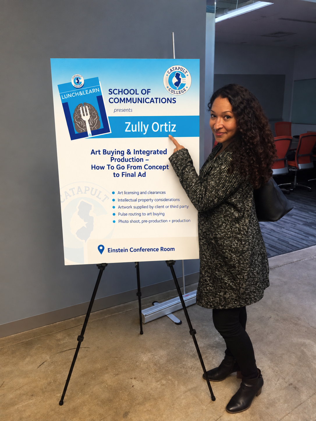Zully Ortiz beside the poster for her talk on art buying and integrated production