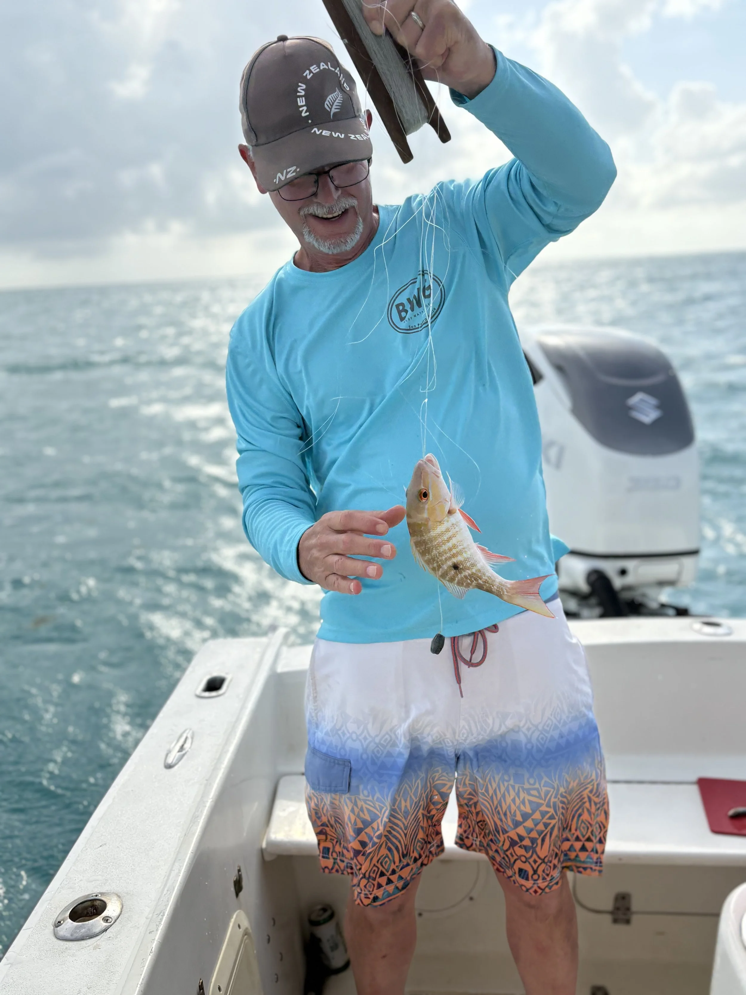 uest holding freshly caught fish after drop fishing trip booked through Casa Al Mar Belize