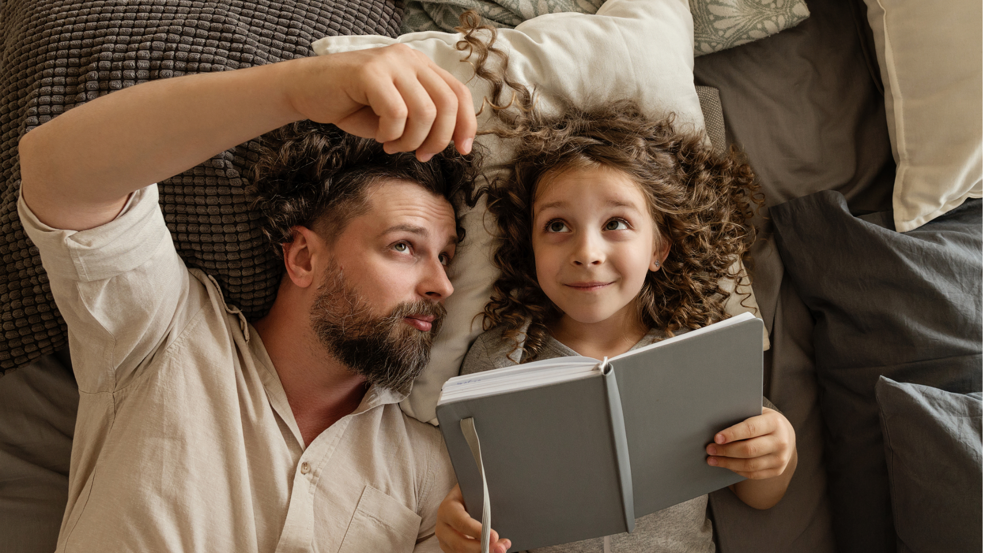 Father and young daughter reading together