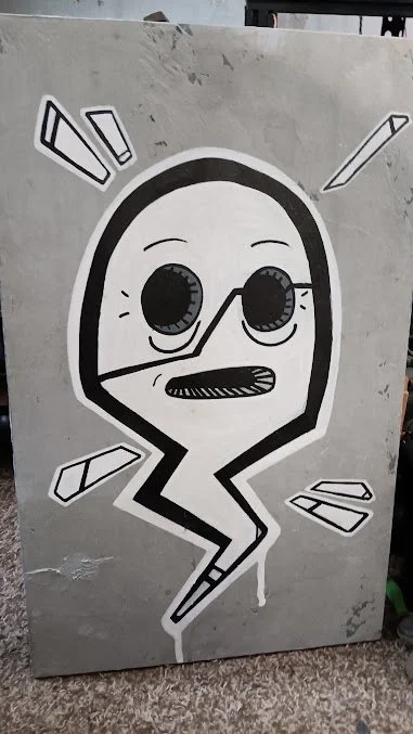 Street art of a lightning bolt character with a face, large eyes, and sunglasses, surrounded by abstract lines on a gray wall.