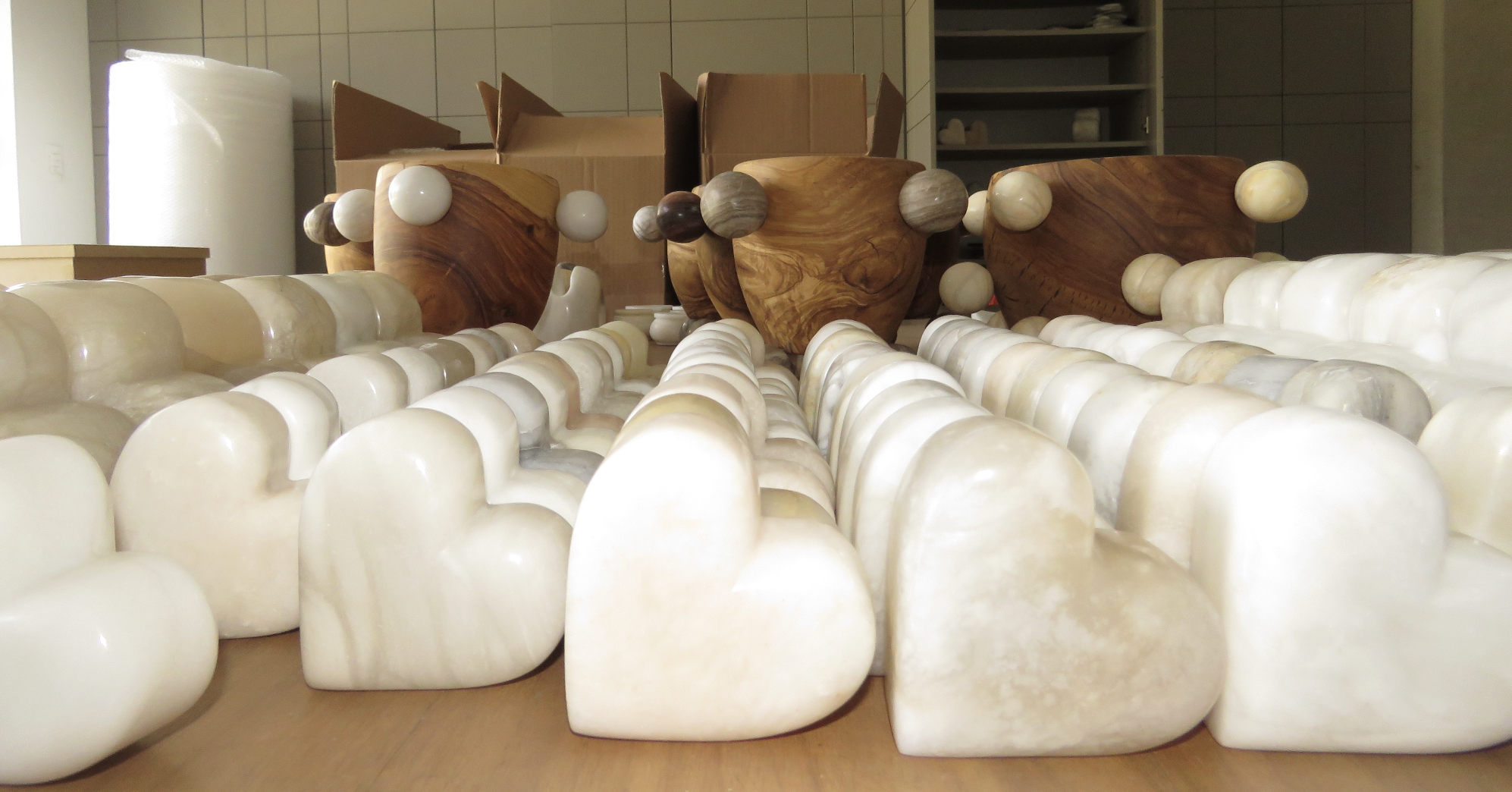 Collection of white and beige decorative stones and wooden bowls on a table.