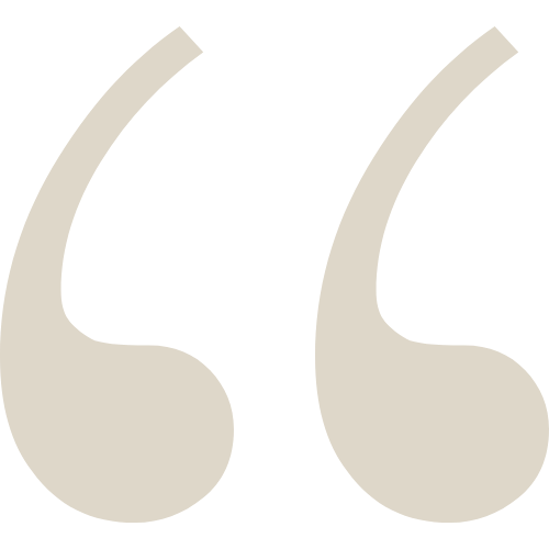 Close-up of beige quotation marks on a black background.
