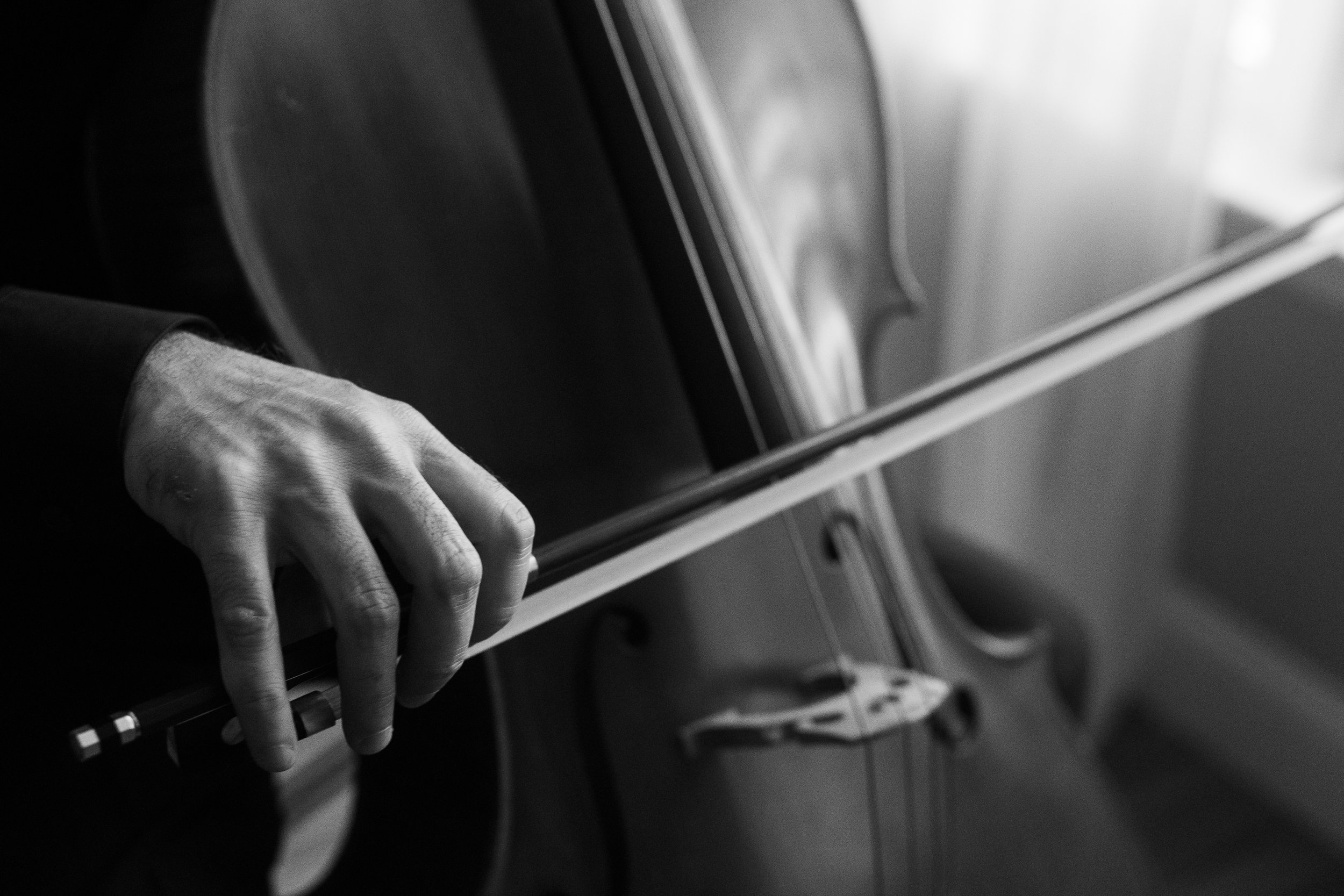 Close-up of a hand playing a keyboard or piano in black and white.