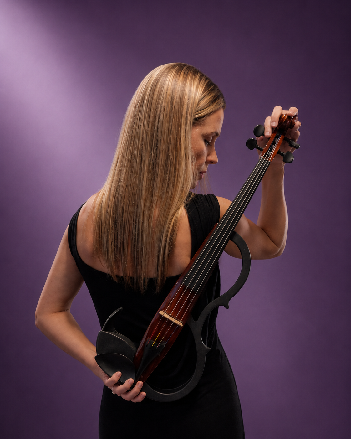 A woman with long blond hair holding a violin with an unusual shape, against a purple background.