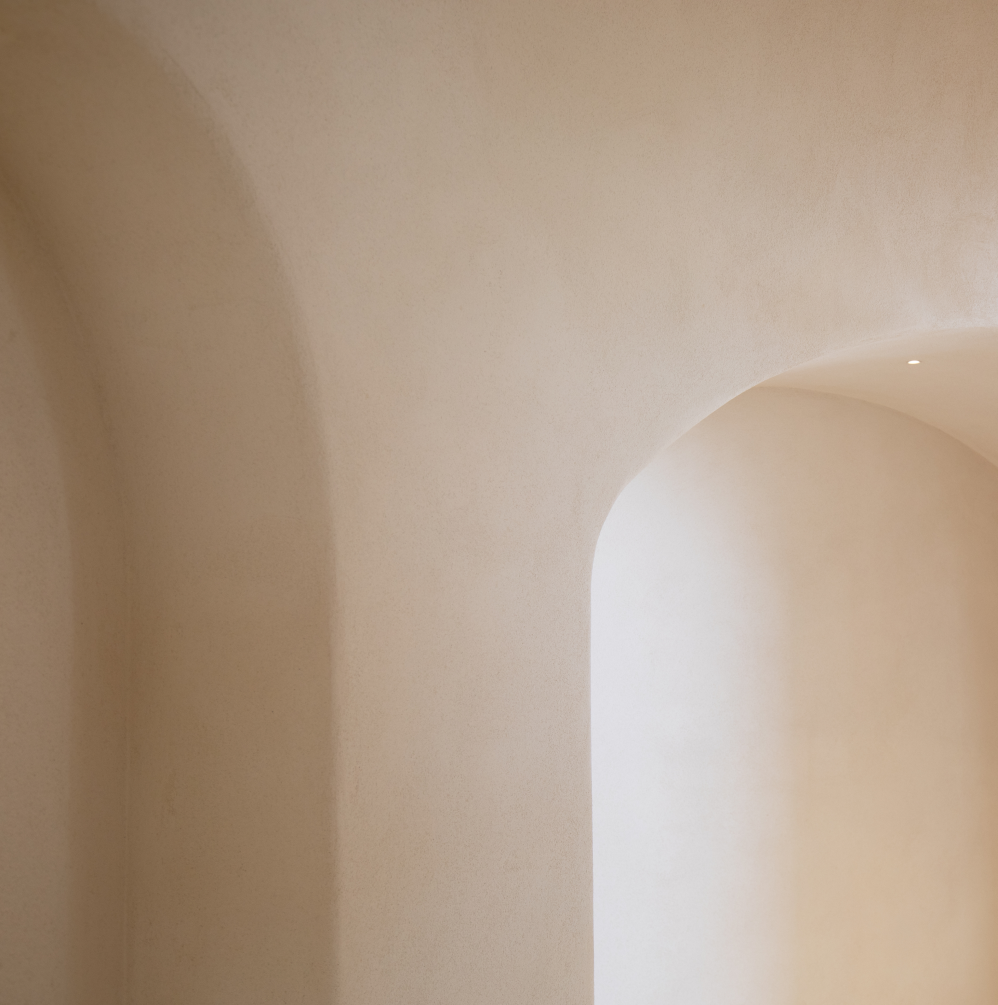 Close-up of a beige interior wall with curved architecture and soft lighting.