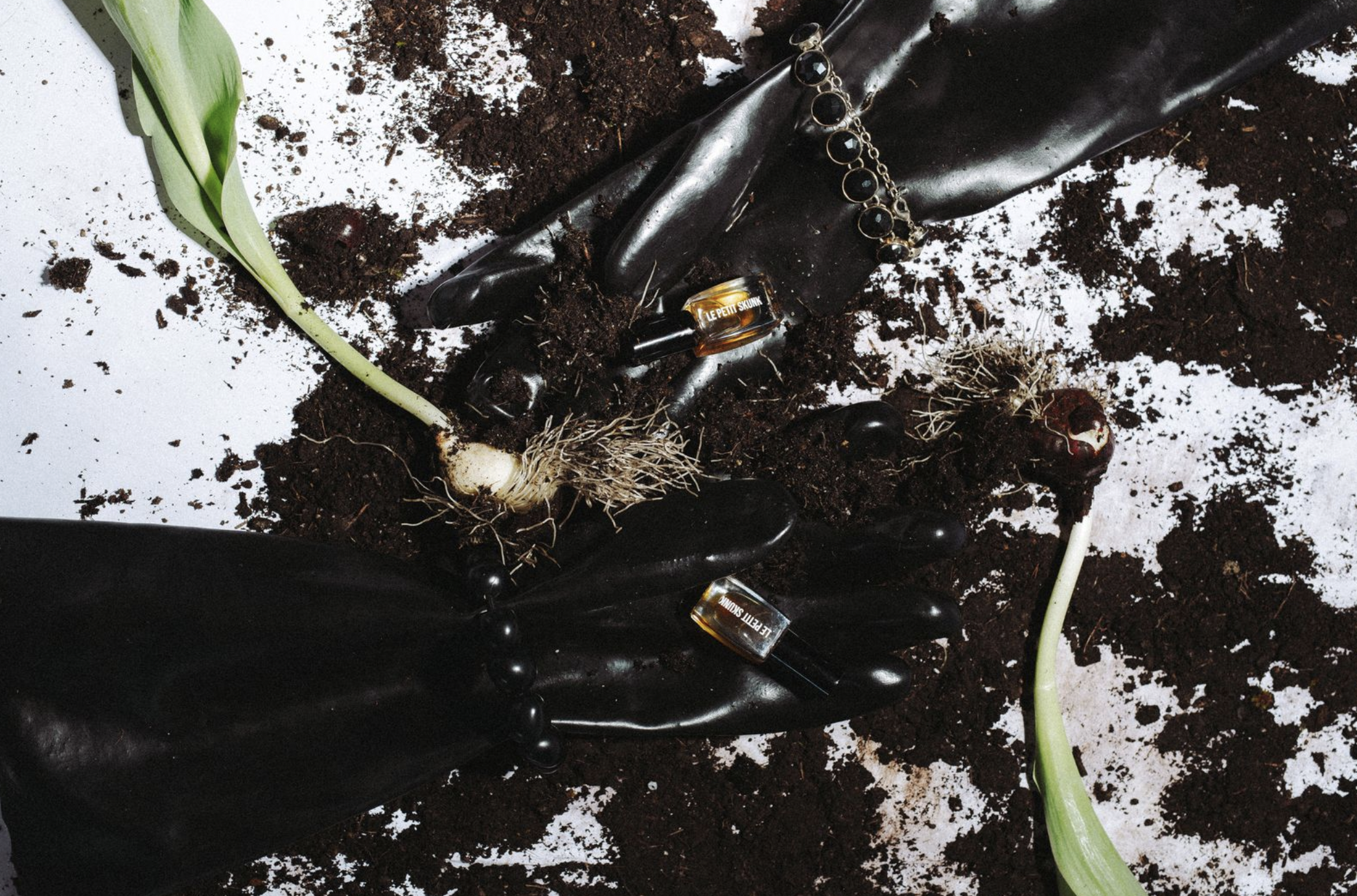 le petit skunk in the dirt with big black worker gloves and jewelry