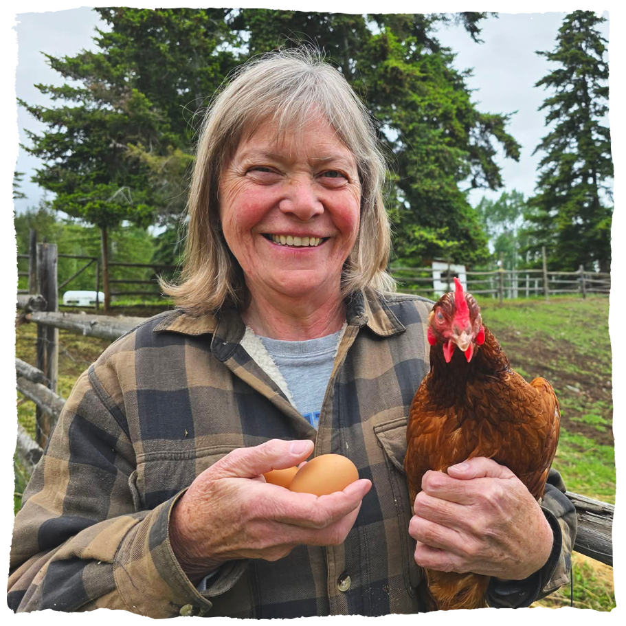 Close up shot of Christine holding a hen in one hand and holding two eggs in the other.