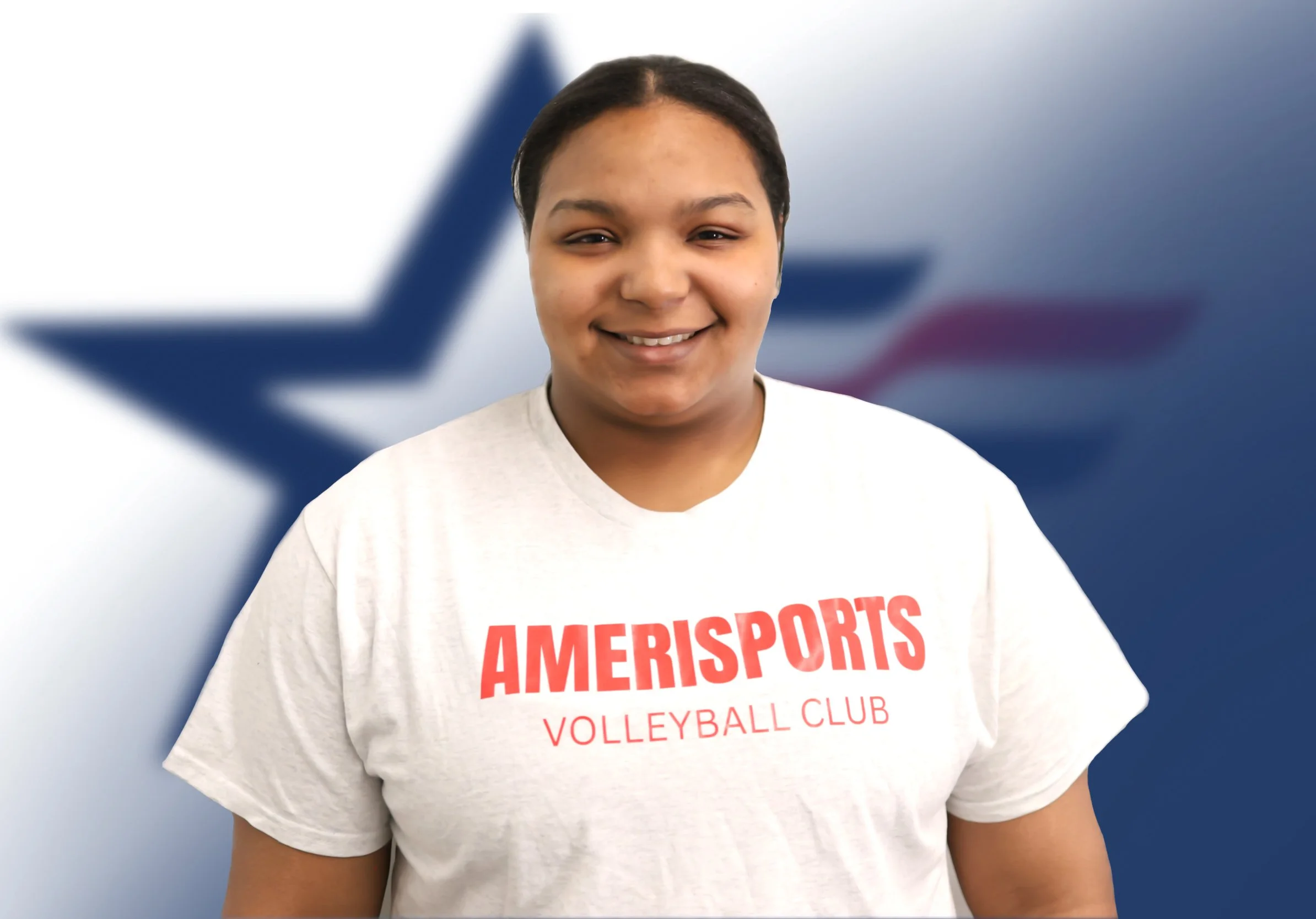 Close-up of a smiling young woman wearing a white t-shirt with red text that reads 'AMERISPORTS VOLLEYBALL CLUB' in front of a blurred background with a blue star and red, white, and blue design.