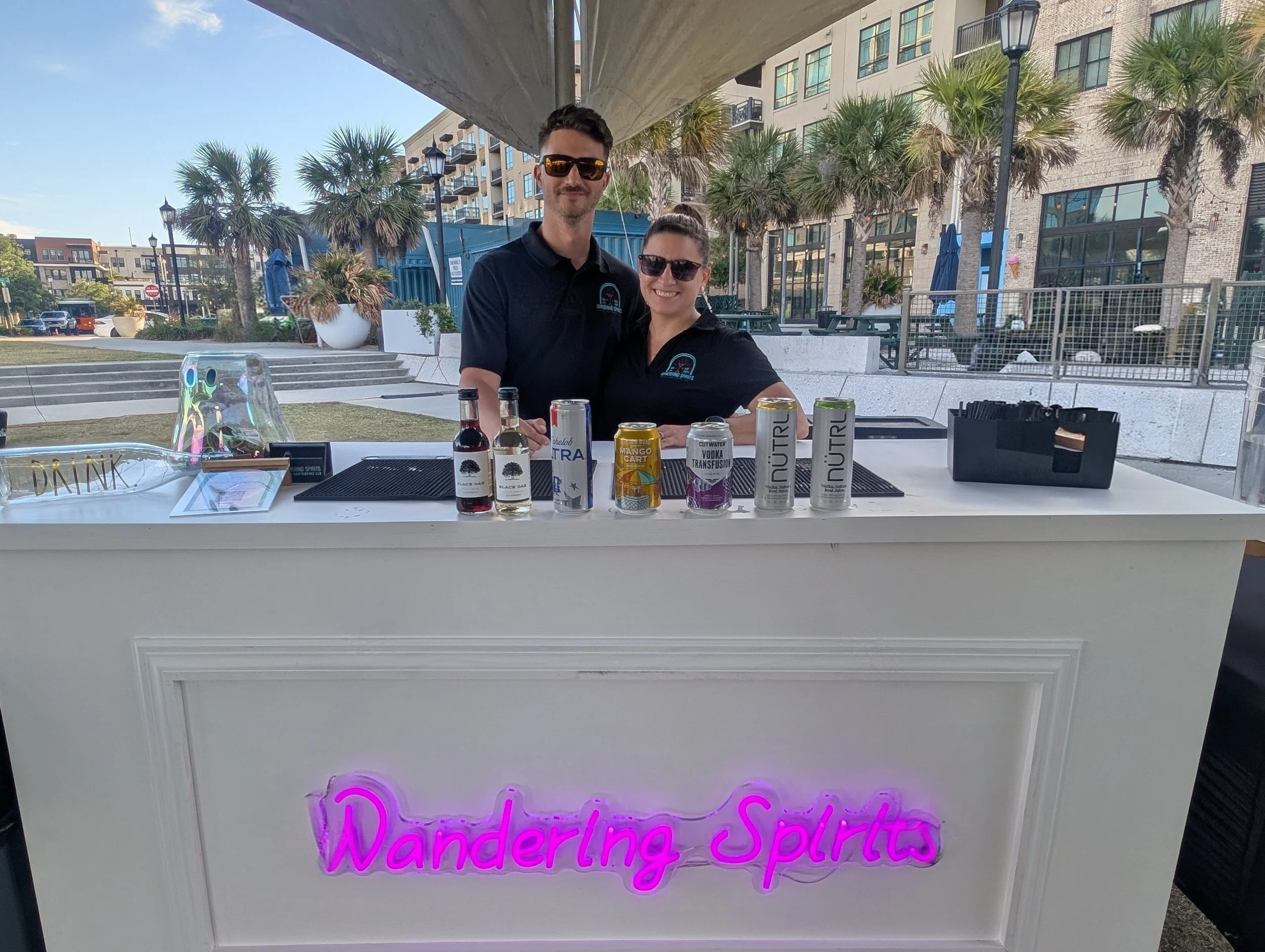 Wandering Spirits Mobile Bartending owners behind a white bar