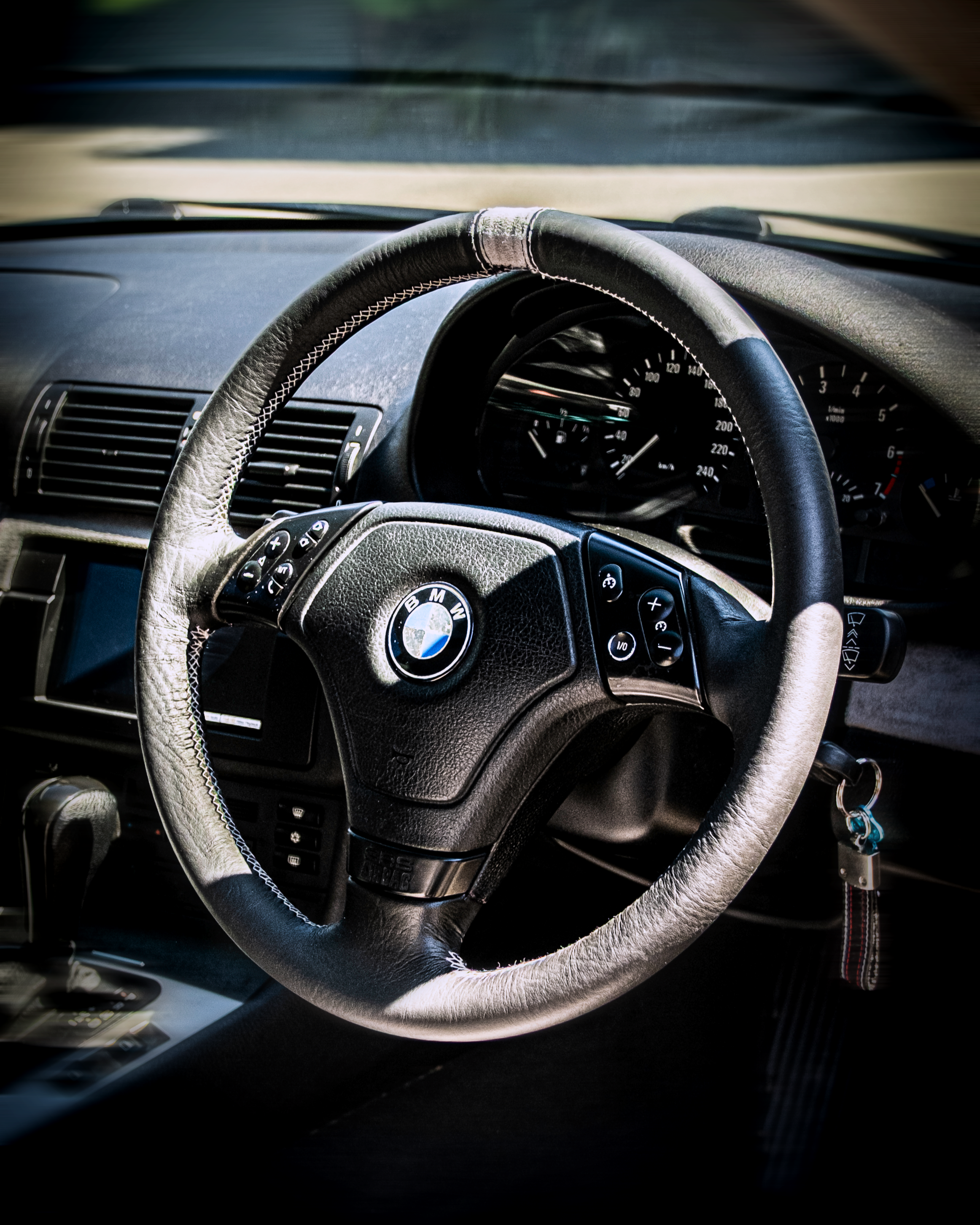 Custom leather steering wheel wrap and retrim by Visions Customs Castle Hill. Premium BMW interior upgrade featuring bespoke stitching and a grey suede 12 o'clock center strip marker.